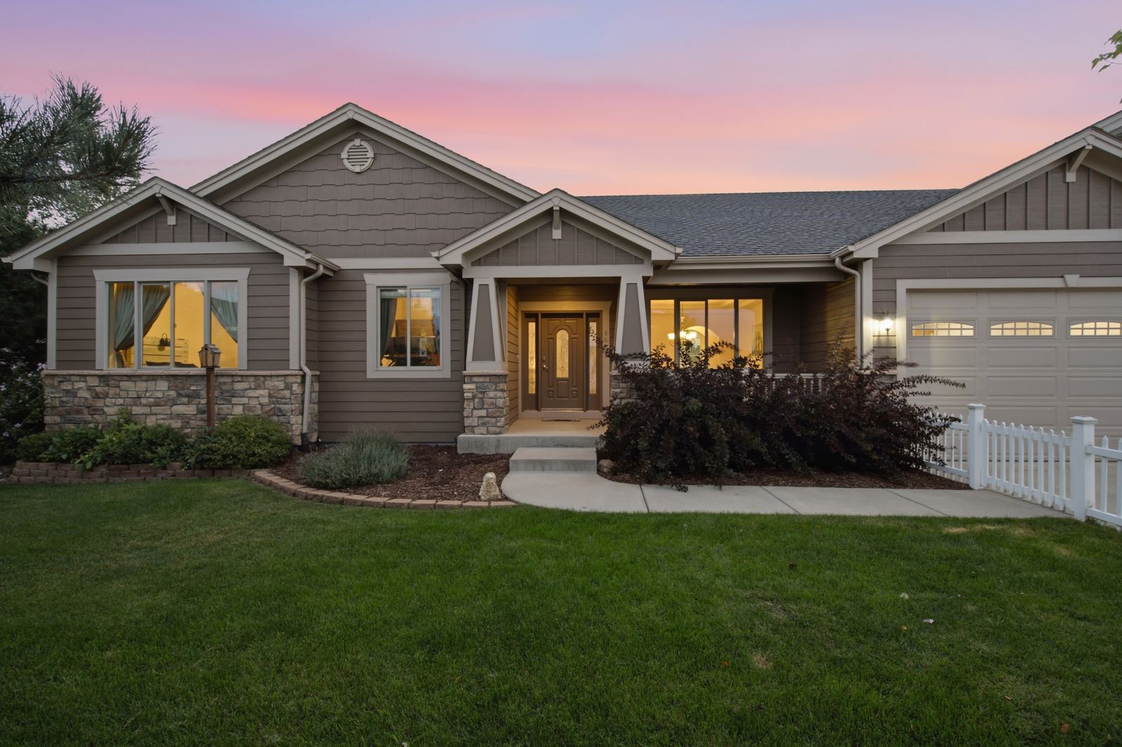 Twilight real estate photo of a Denver ranch home with interior lights on